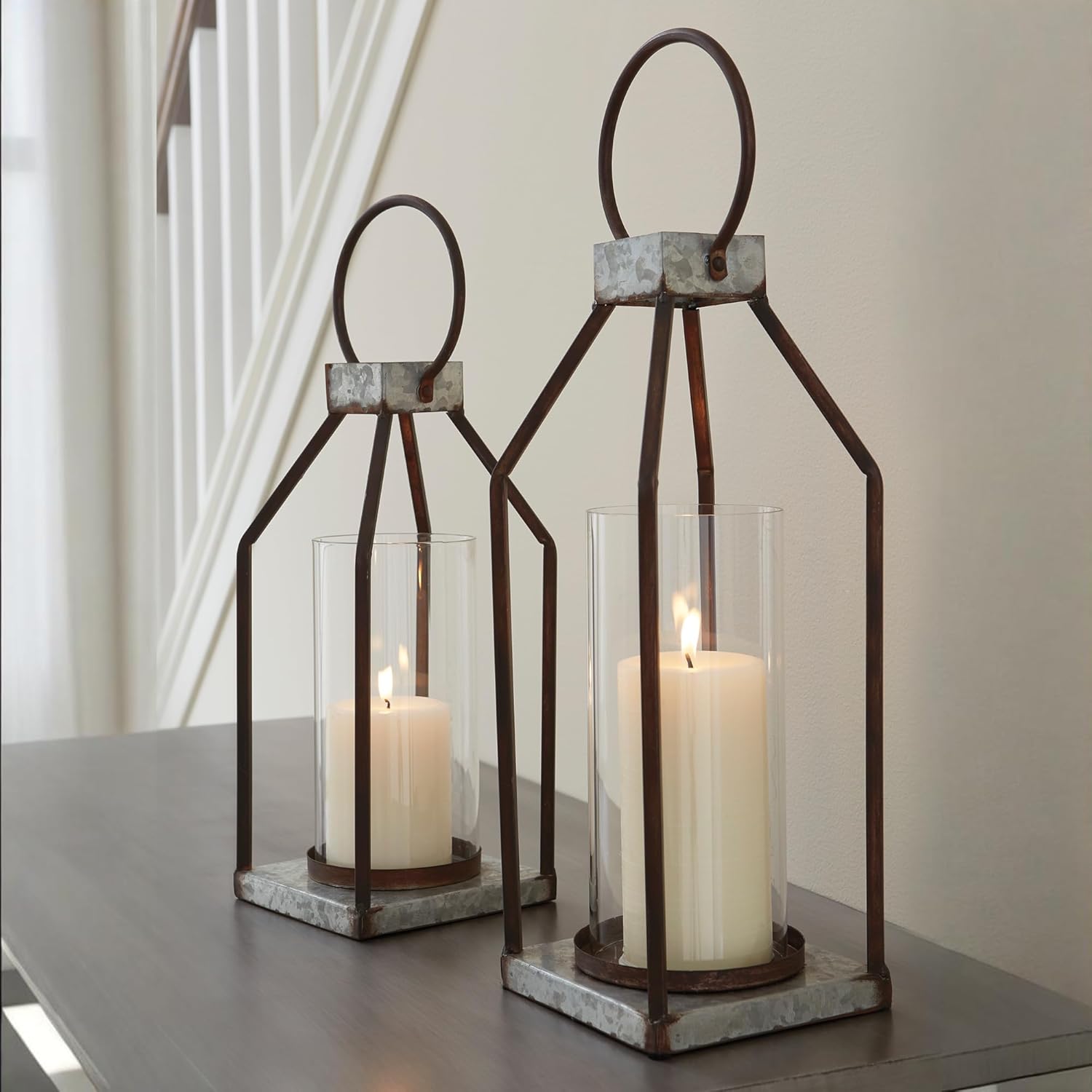 Signature Design by Ashley Diedrick Rustic Lantern, Set of 2, Indoor/Outdoor, Galvanized Metal, Antiqued Finish, Glass Shade, Holds 3 in. Pillar Candles (Not Included), 19" &17", Gray and Black